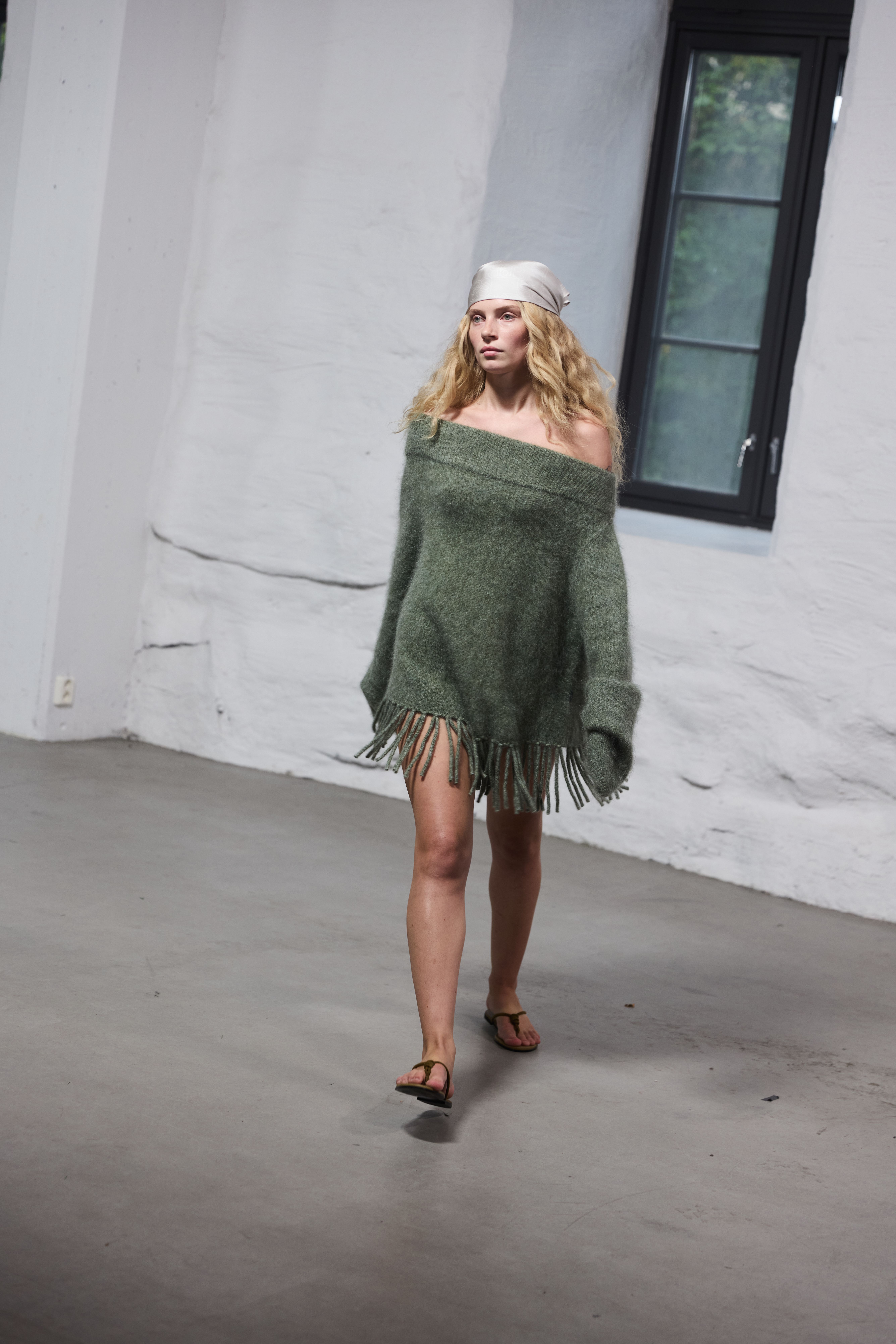 Ella&il model wearing a green off-the-shoulder knit with a fringed hem